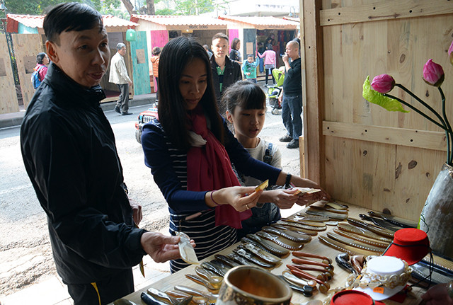 向游客介绍涂漆、柳条编结、陶瓷、刺绣 、木材、纺织品、纸制品、民间画、金属、石雕、玻璃、蜡烛、精油等河内工艺村的传统产品。（图片来源：越南《人民报》）