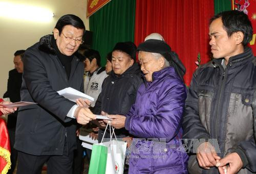 张晋创主席向禄平边境县的姆山、秀幂、安快等三乡居民赠送礼物。（图片来源：越通社）