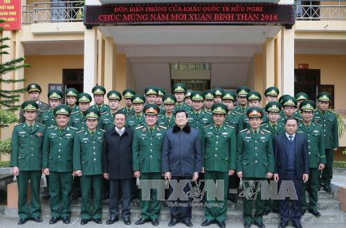  张晋创主席友谊国际口岸边防哨所干部战士以及正在友谊关工作的海关、边防、检疫、同登-谅山口岸经济区管委会等力量合影。（图片来源：越通社）