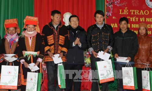 张晋创主席向禄平边境县的姆山、秀幂、安快等三乡居民赠送礼物。（图片来源：越通社）