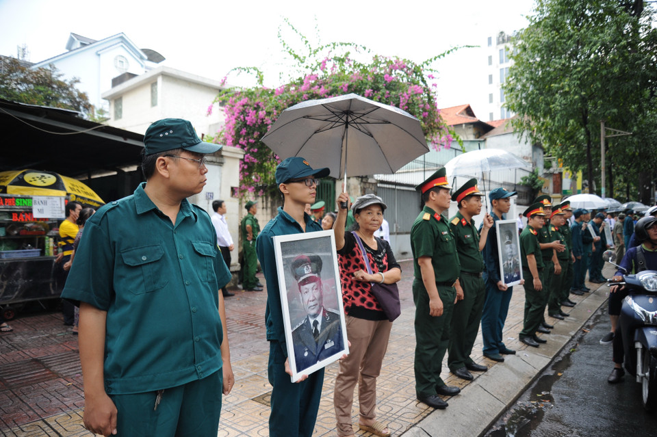 自卫民兵力量和胡志明市市民拿着原国家主席黎德英的遗像在路边等候黎德英灵车。图自越通社