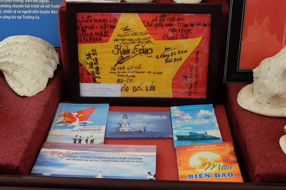 海岛战士们将被风雨侵蚀和撕破的国旗留下来，并在国旗上面签字并寄回后方，在岛屿空间展示，供游客参观了解。图自越通社