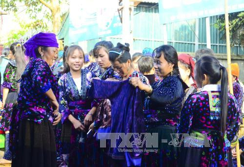在舍雅​集市挑选衣服准备迎春的少数民族少女（图片来源：越通社）​