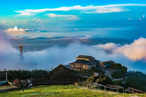 云雾围绕着母山峰顶上法式建筑的屋子；游客在一条小路散步、尽情享受平安、安详的生活（图片来源：vnexpress.net）