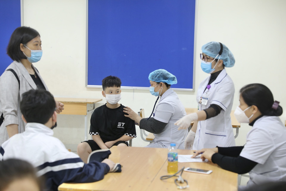 接种前，医务人员对学生进行全面筛查评估。图自越通社