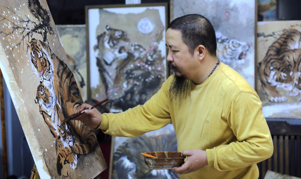 画家阮端宁在构树皮纸上画老虎。图自越南画报