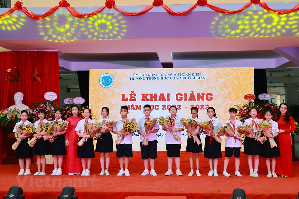 9月5日上午，越南全国63个省市中的44个省市以灵活、多样的形式举行新学年开学典礼，确保安全、简洁、切实，充分体现了师生们克服困难，完成教学任务的决心。其中，24个地方的师生参加现场开学典礼，20个地方通过网络或电视举行线上开学典礼。图为初中一年级学生接受学校领导班子赠送的鲜花。图自Vietnam+