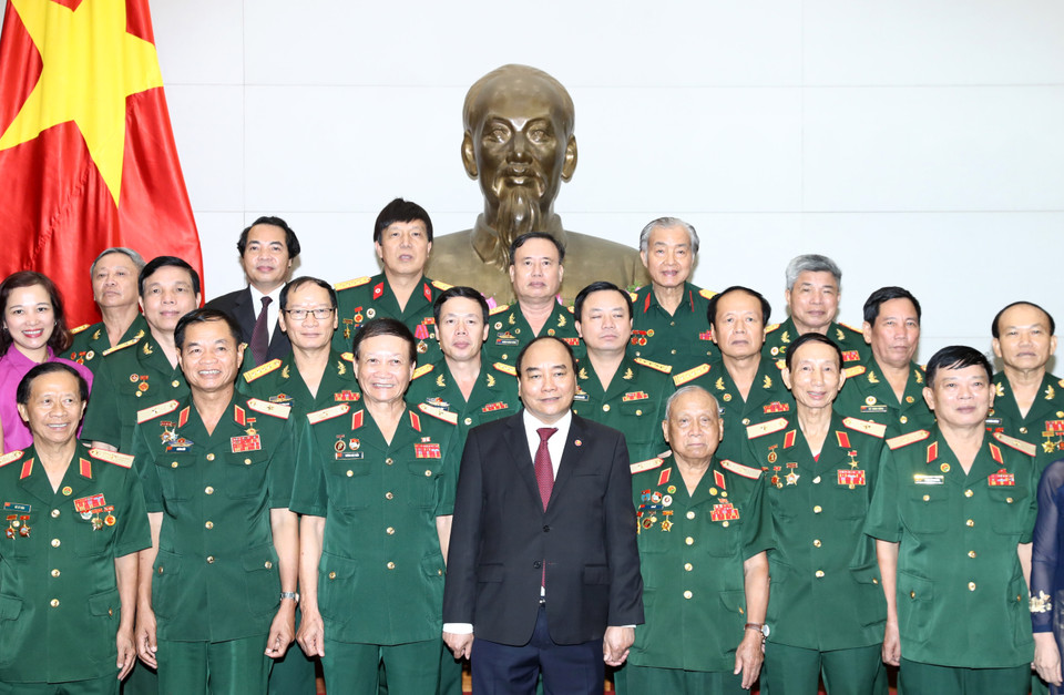 与会代表与阮春福合影留念。（图片来源：越通社）