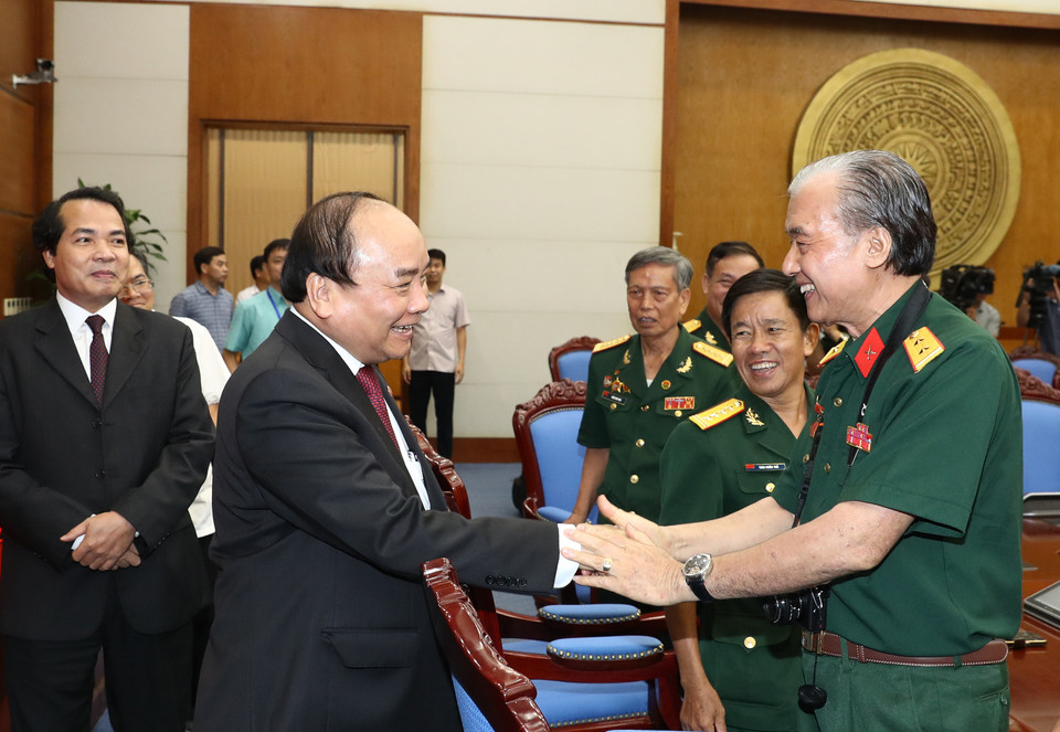 阮春福与长山部队老战士代表亲切握手。（图片来源：越通社）