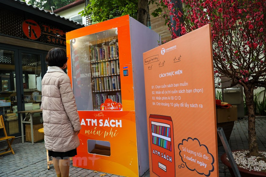 “2021年辛丑春节图书街”活动的一个有趣的亮点就是通过图书自动提取机（图书ATM机）。读者只要输入他们的姓名、电话号码、地址和书名就可通过该图书AMT机免费获得图书。这款图书ATM机由泰河图书公司董事长兼首席执行官阮孟雄研究投资，目的是服务广大人民的看书需求。图自越通社/ Vietnam+