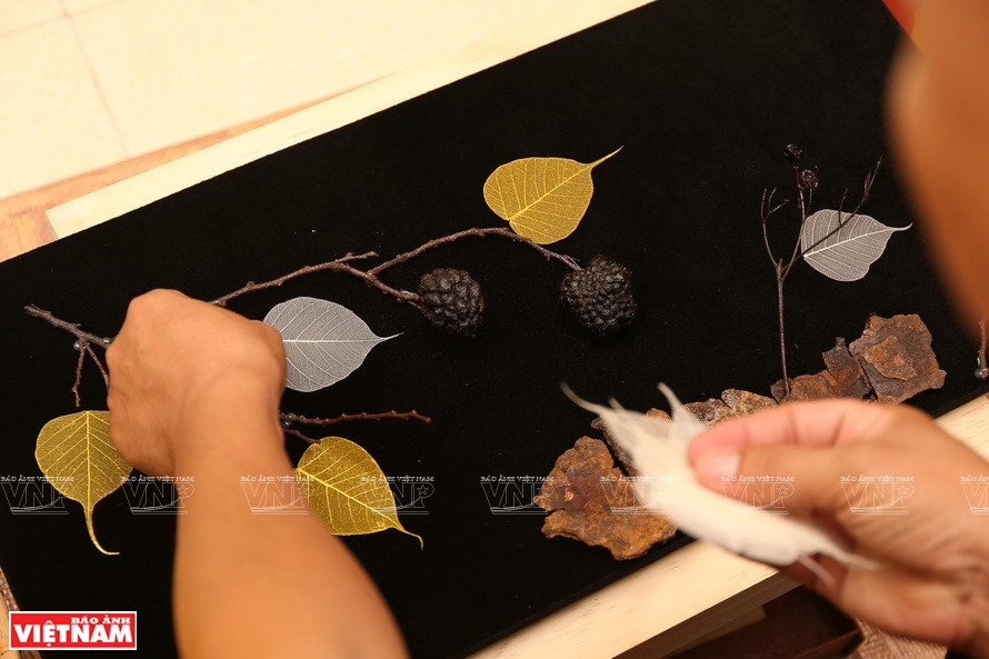 工匠将菩提叶拼贴在一个干树枝。这是名为《渴望》的菩提叶拼贴画。图自 越通社/越南画报