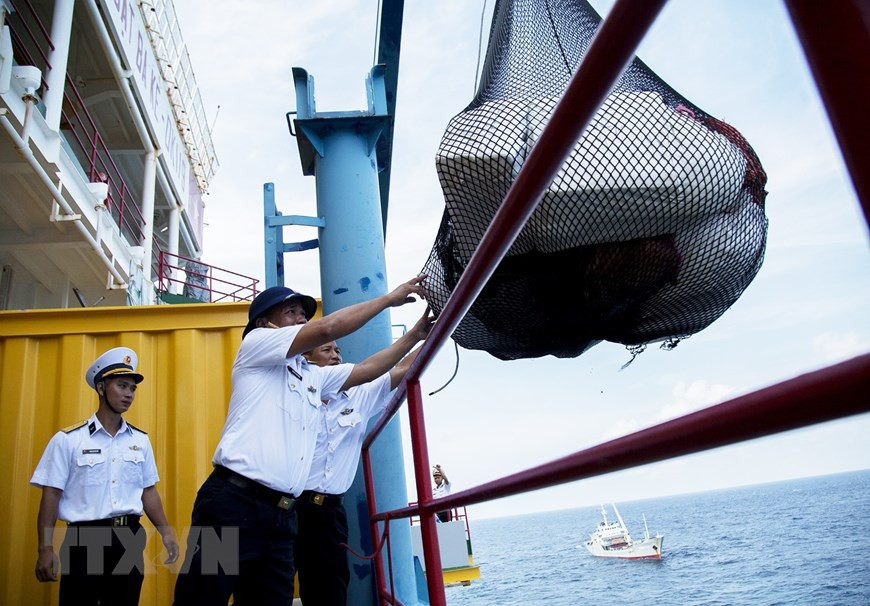 DK1干部战士从起重机获取陆地人民赠送的年货。图自越通社