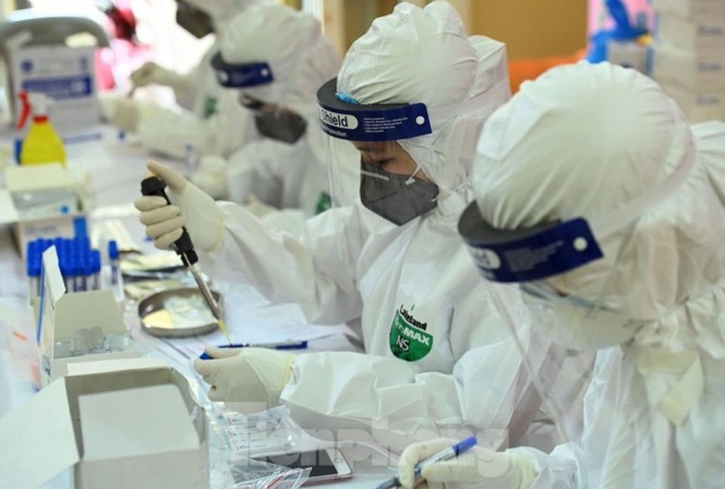 医务人员对检测样本进行处理。图自越通社