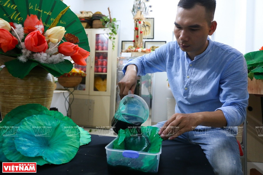 制作荷叶画得经许多工序，如挑选荷叶、染色、烘干、加工、完善等。他将荷叶浸泡在安全的防腐剂以增加叶子的耐久性。图自《越南画报》