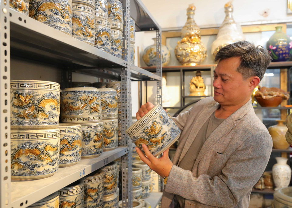 顾客在钵场陶瓷村选购龙凤香炉。图自越通社