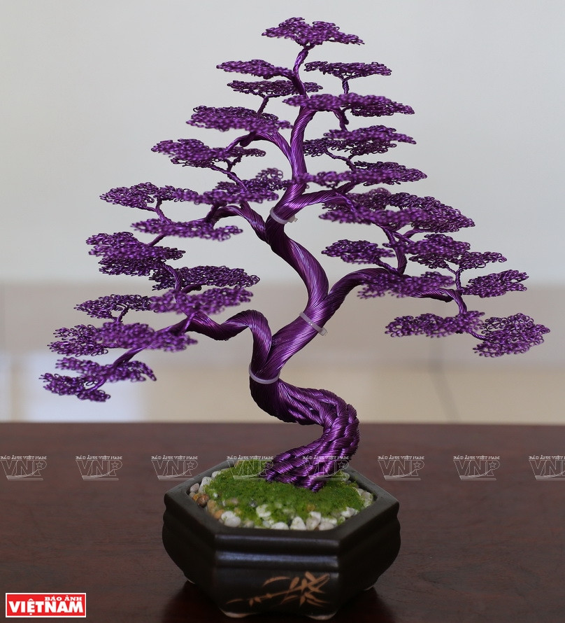 在范文营的灵巧双手下，由铜线制成的一棵棵树开始成型。图自越通社