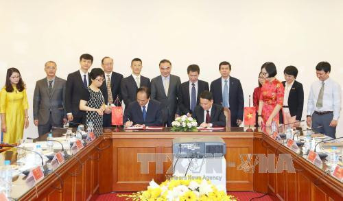 阮德利与蔡名照签署越通社与新华社之间的合作备忘录。（图片来源：越通社）