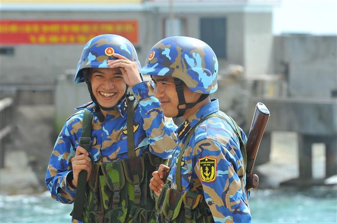 在执行任务时，尽管较为困难，但他们仍保持微笑出色完成各项任务。图自越通社