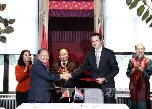 越南政府总理阮春福与荷兰首相马克•吕特见证越南农业与农村发展部与荷兰基础设施与环境部关于减轻自然灾害议定书互换仪式。（图片来源：越通社）