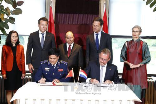 越南政府总理阮春福与荷兰首相马克•吕特见证越南海警力量代表与荷兰达门造船集团代表关于6艘多功能海警船造船项目协议签署仪式。（图片来源：越通社）