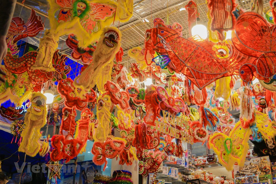 摆着灯笼、面具、鼓、麟头等传统玩具的店铺是年轻人聚集的地方。越通社记者 明孝摄