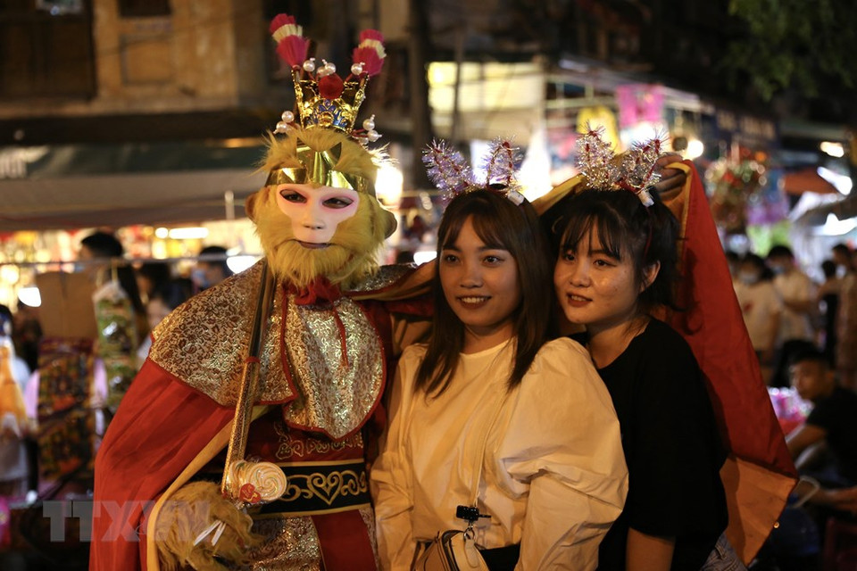 年轻人与“齐天大圣”合影留念。越通社记者 黄孝 摄