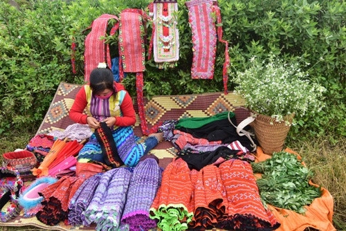 游客可以在芥菜花田边的小摊买到当地纪念品送给亲朋好友。（图片来源：人民军队报）