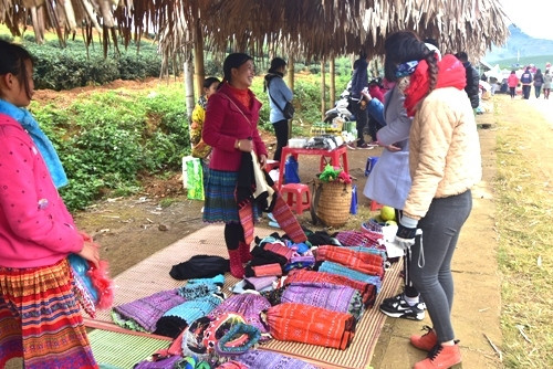 游客可以在芥菜花田边的小摊买到当地纪念品送给亲朋好友。（图片来源：人民军队报）