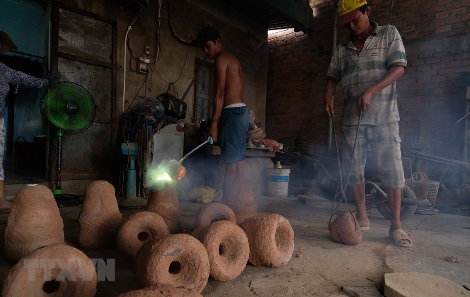 工匠把铜水灌入已造型的土模具。越通社记者 阮勇 摄