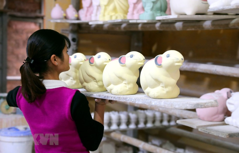艺人们抓紧完成生肖鼠陶瓷摆件放入窑炉前的工序。越通社记者 成达 摄