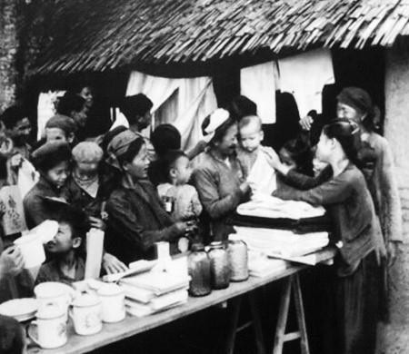 在土地改革中获得土地的农民兴高采烈购买家用品。图自越通社