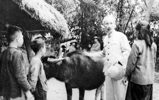 1955年，胡志明主席走访在土地改革中获得土地的一个农户。图自越通社