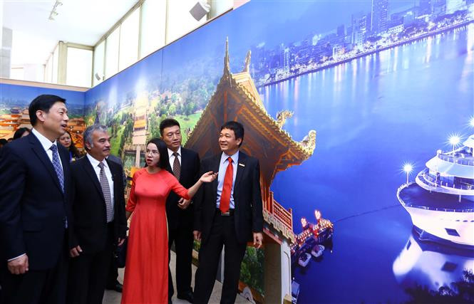 代表们参观该图片展。（图片来源：越通社）