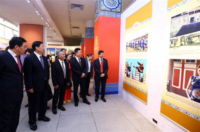 代表们参观该图片展。（图片来源：越通社）