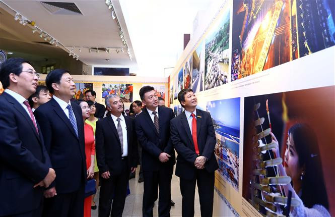代表们参观该图片展。（图片来源：越通社）