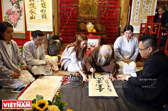 著名书法家弓亥略在2019年春节书法节写字。图自越南画报