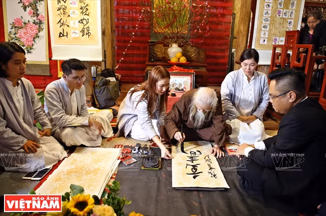 著名书法家弓亥略在2019年春节书法节写字。图自越南画报