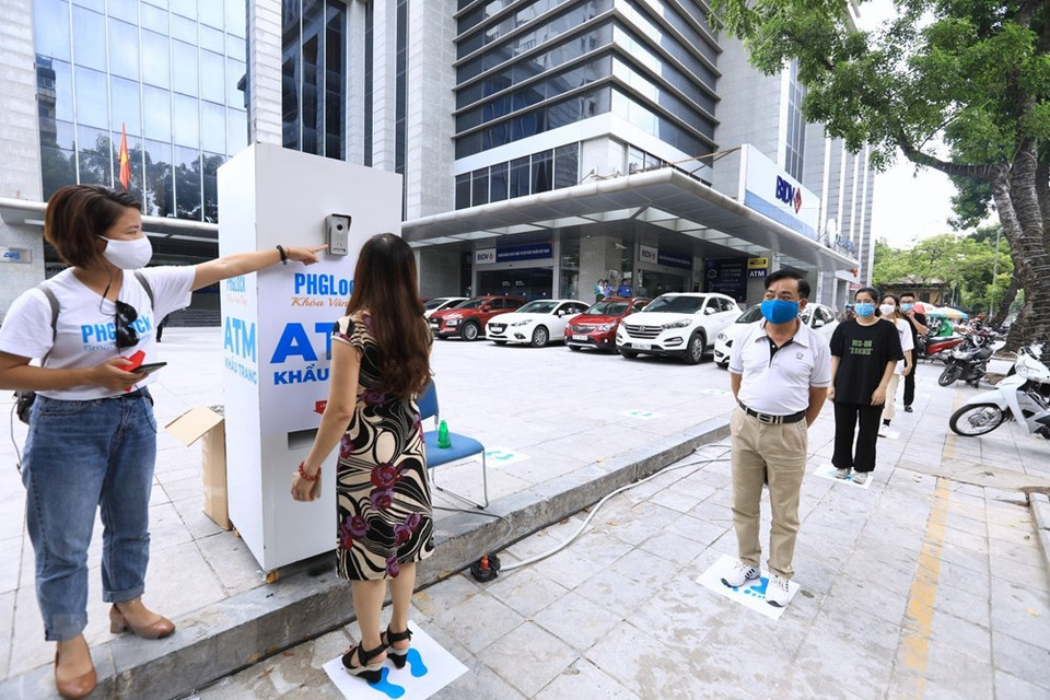 居民们排队等待领取口罩时仍需要保持安全距离。越通社记者 成达 摄