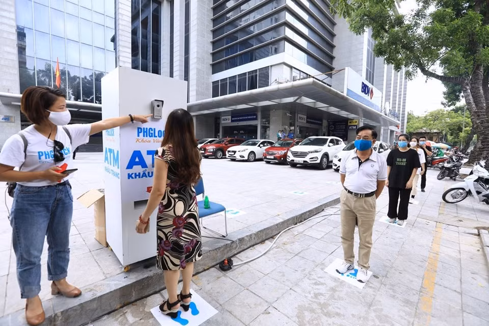 居民们排队等待领取口罩时仍需要保持安全距离。越通社记者 成达 摄