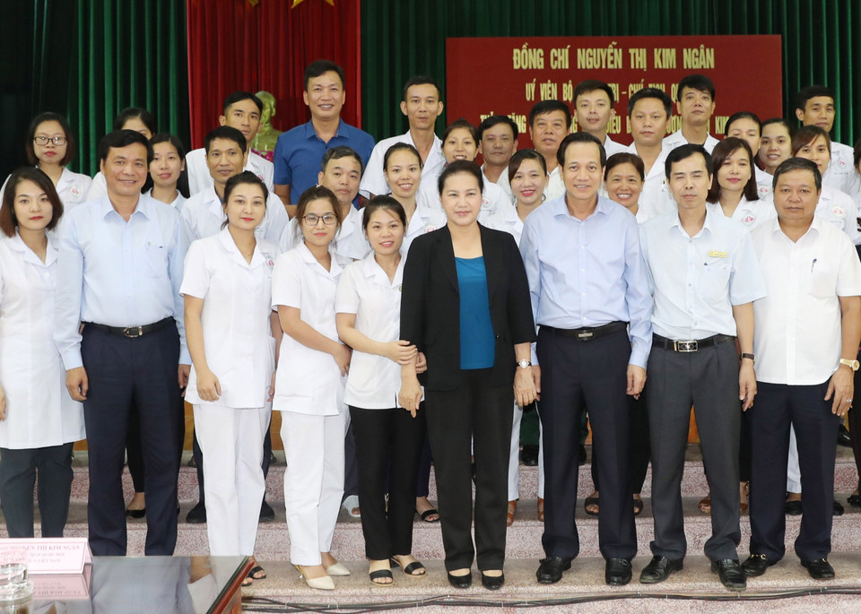 国会主席阮氏金银和劳动荣军与社会部部长陶玉容与金榜伤残军人疗养中心干部人员合影。越通社记者 仲德 摄