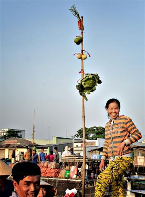 小船上的竹竿挂着该船出售的货物。（图片来源：越南《人民军队报》）