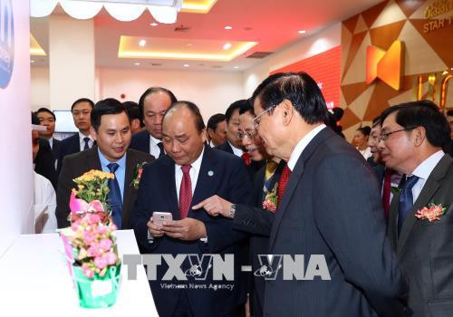 越南政府总理阮春福与老挝政府总理通伦·西苏里走访参观老挝星光电信公司。越通社记者 统一 摄