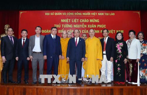 阮春福与越南驻老挝大使馆工作人员和旅老越南人代表​合影。越通社记者 统一 摄