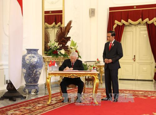 阮富仲在印尼总统府留言薄上留言。（图片来源：越通社）