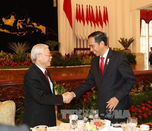 阮富仲与佐科·维多多在招待宴会上握手。（图片来源：越通社）