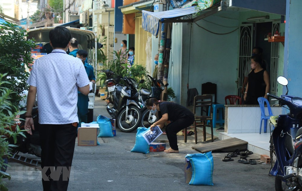 第六郡7号坊陶瓷窖巷E弄的居民接受援助粮食。越通社记者 丁恒 摄
