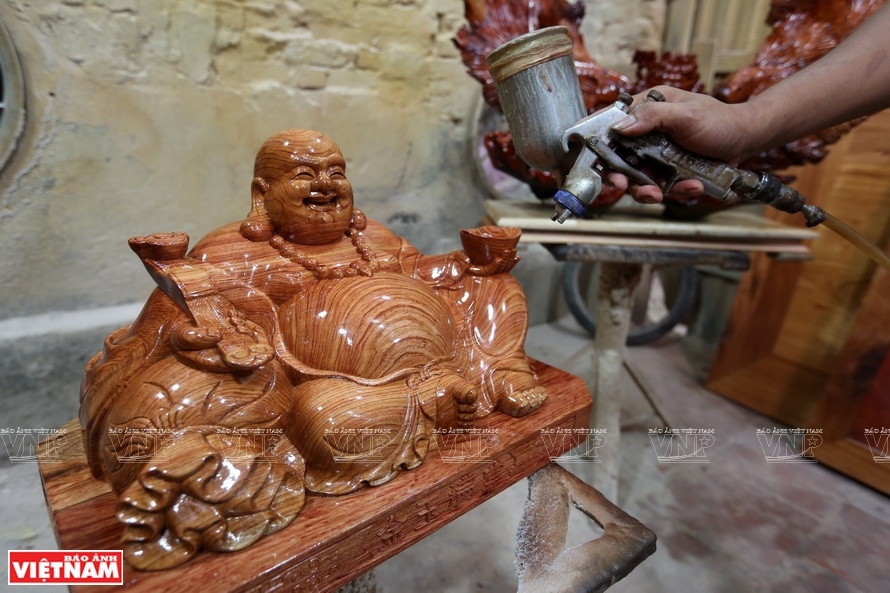 工匠对木制产品喷光油。图自《越南画报》