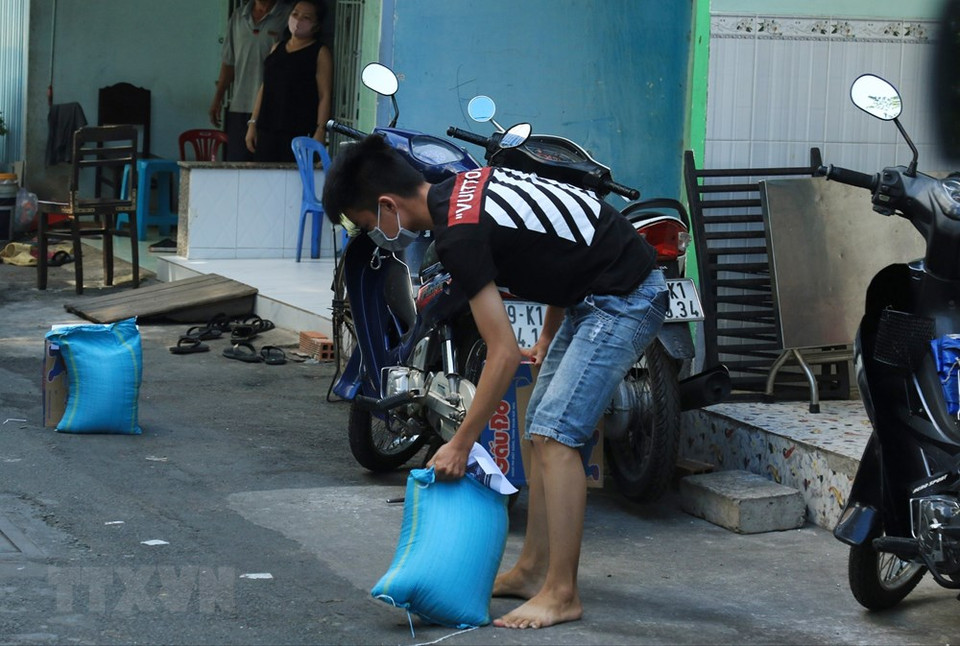 第六郡7号坊陶瓷窖巷E弄的居民接受援助粮食。越通社记者 丁恒 摄