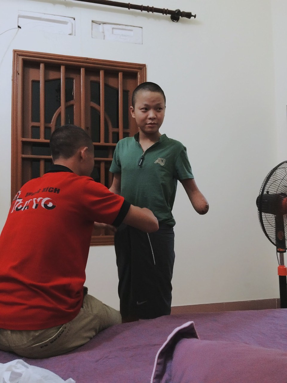 这个年轻人因遇到事故两手腕都被截肢。图自越通社