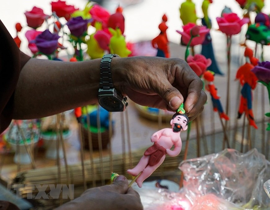 艺人按客户的要求来制作面塑。图自越通社。